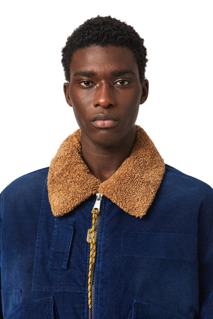 Diesel blue denim jacket close-up: tan shearling collar and gold-tone zip pull