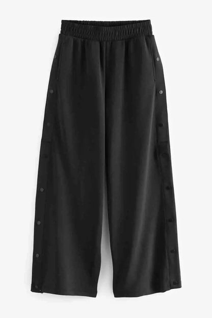 Charcoal grey wide-leg trousers with elastic waist and side button tabs