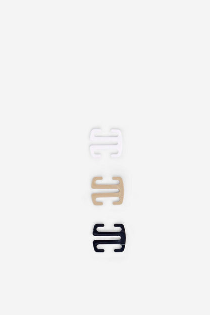 Cross-strap accessory pieces, white and dark ends, on backing card