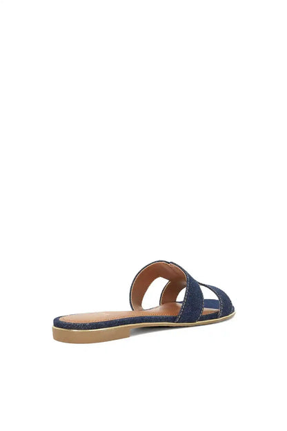 Navy denim slide sandals with open toe, single backless strap, and tan outsole