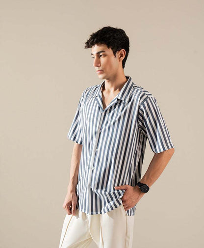 Fitted blue-and-white vertical striped short-sleeve button-up shirt, hands near pockets