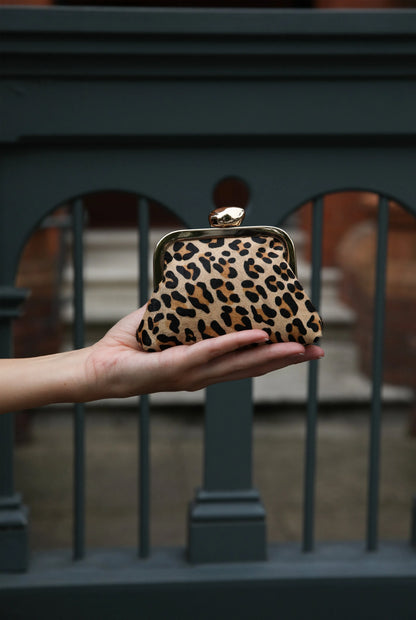 Leopard-print mini handbag held up, showing gold-tone top clasp