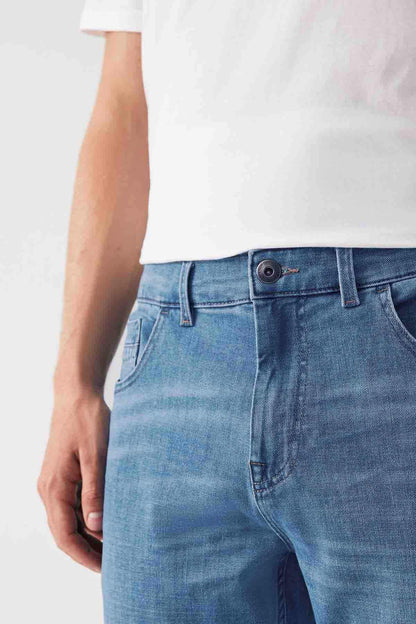 Light blue denim jeans close-up of waist with button fly, belt loops, and stitched pockets