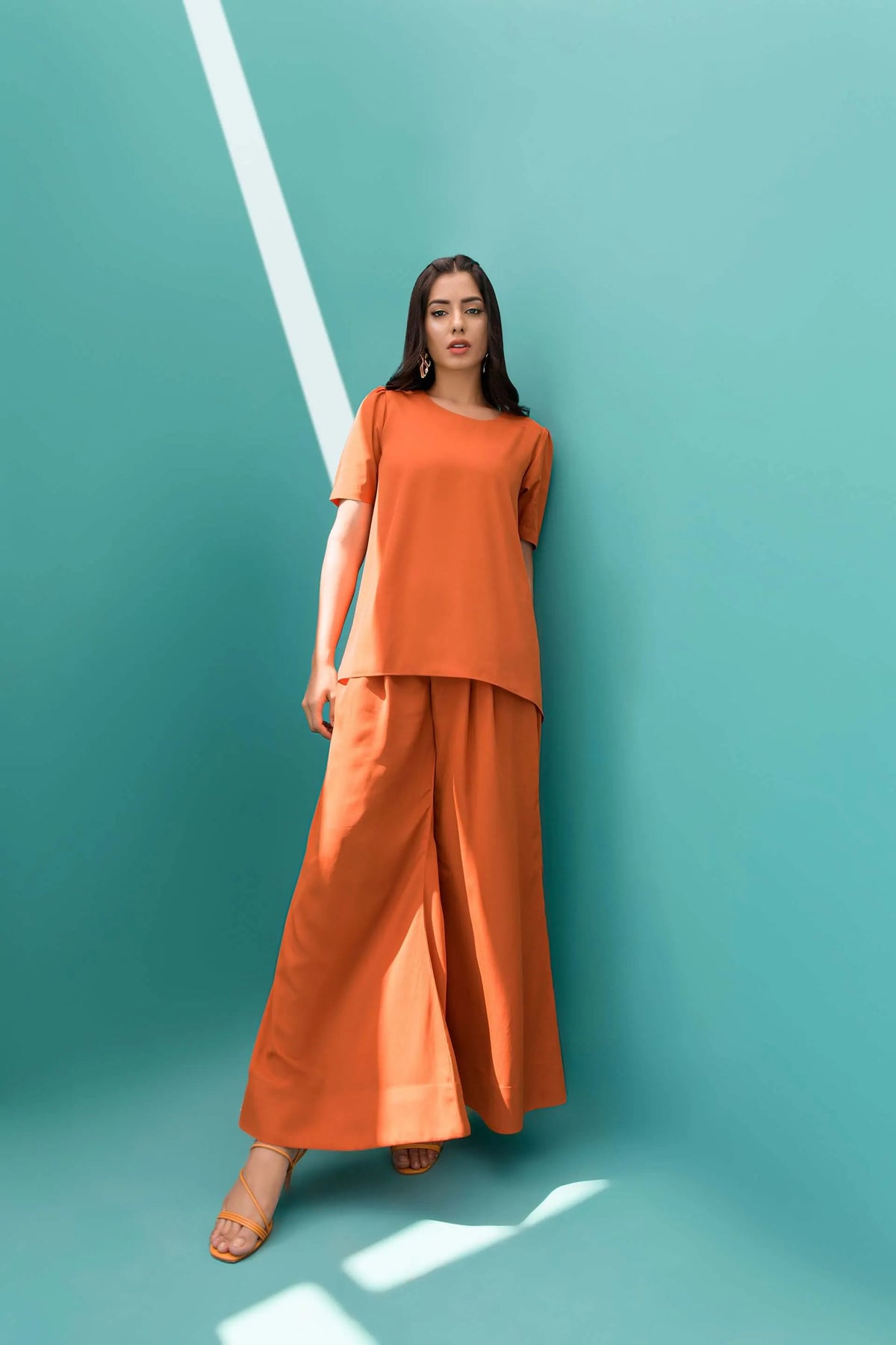 Orange velour tunic and wide-leg pants, standing front with slight step