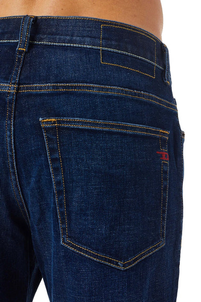 Blue denim jeans rear pocket with contrast yellow stitching.
