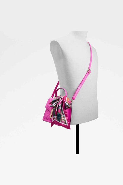 Pink quilted mini handbag on mannequin with shoulder strap and scarf accent