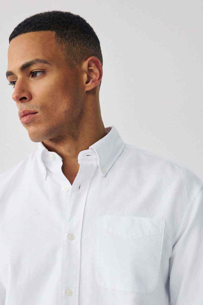 Men's white button-up shirt detail: collar and chest pocket