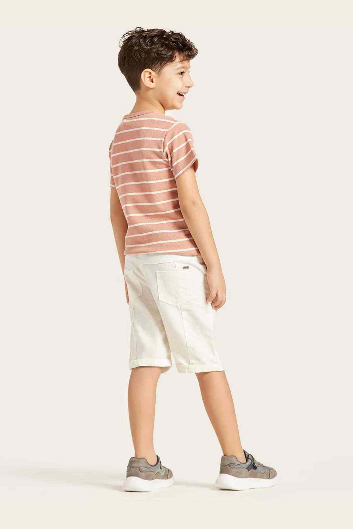 Children's pink-and-white striped T-shirt with white shorts, side view