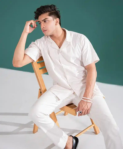 Off-white fitted short-sleeve shirt with button placket and matching pants, side view