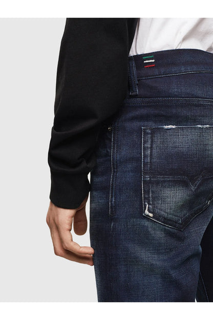 Indigo denim jeans close-up of back pocket with distressed detail