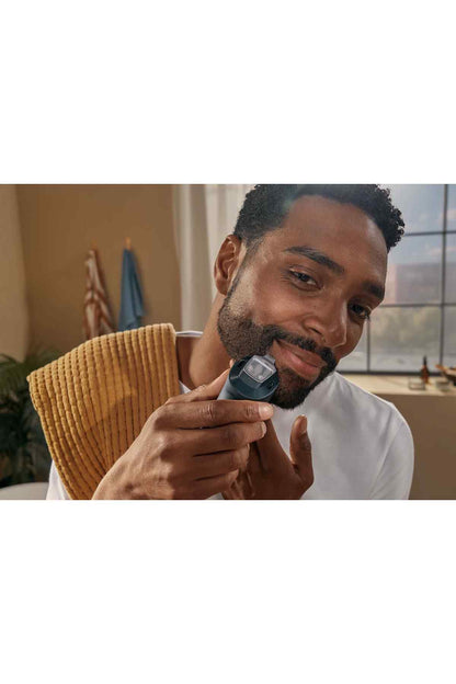 Electric beard trimmer, black, being used on facial hair