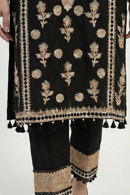 Black lower outfit with gold embroidered motifs and tassel-trimmed hem detail