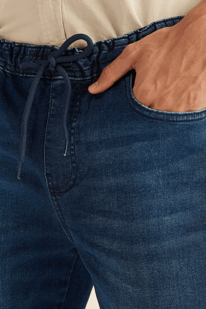 Blue denim jogger jeans close-up: drawstring waist and front pockets