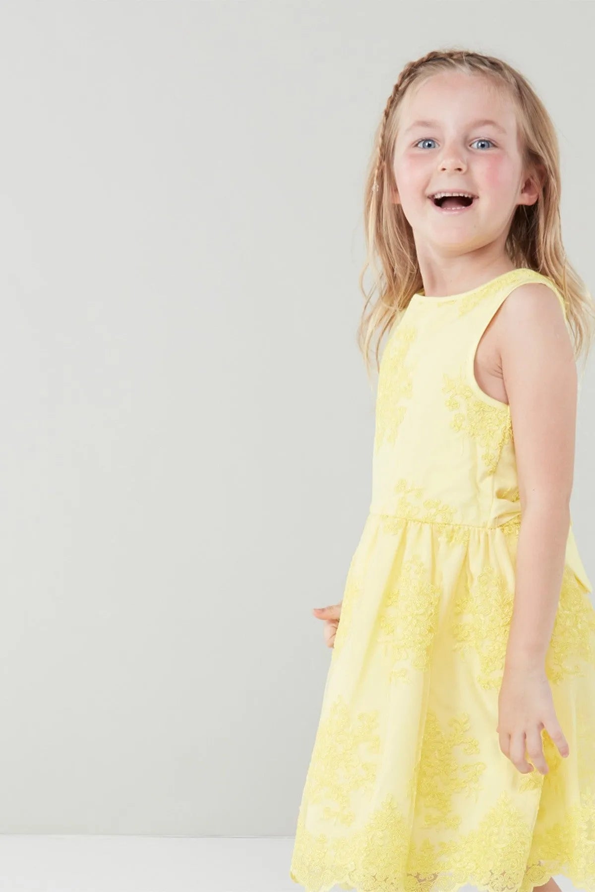 Yellow sleeveless toddler dress with round neckline, gathered skirt and floral print