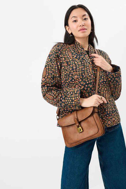Tan crossbody bag with front flap, gold-tone buckle, and adjustable strap