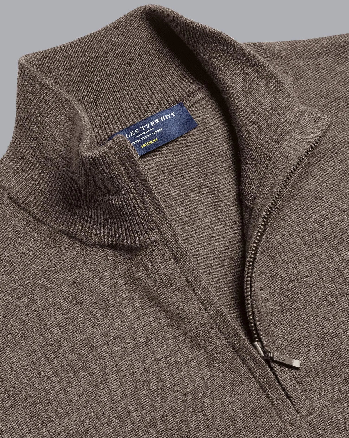 Men's brown quarter-zip knit sweater label and zip detail