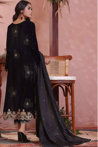 Black embellished long dress from back view with gold trim and flowing cape drape