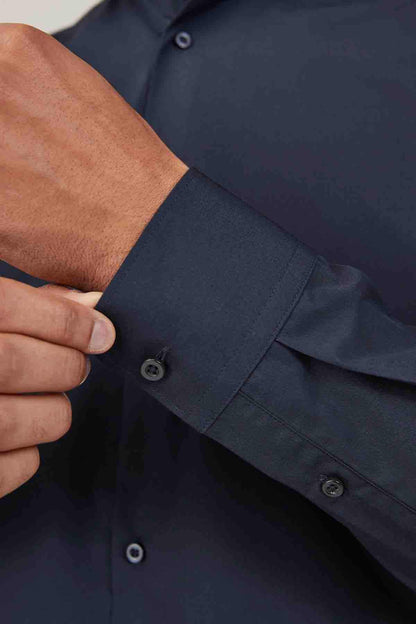 Navy dress shirt cuff and sleeve placket detail with buttons.