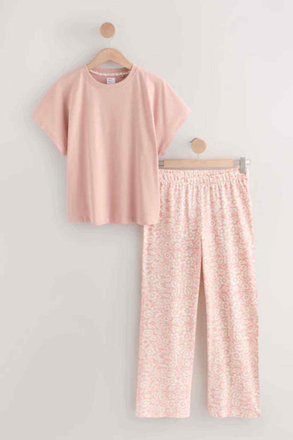Pink T-shirt and matching patterned wide-leg pants set on hangers