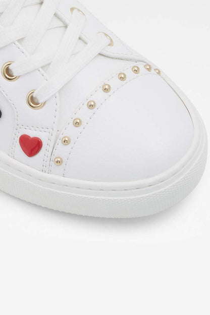 ALDO white sneaker toe close-up with red heart patch, gold eyelets, laces