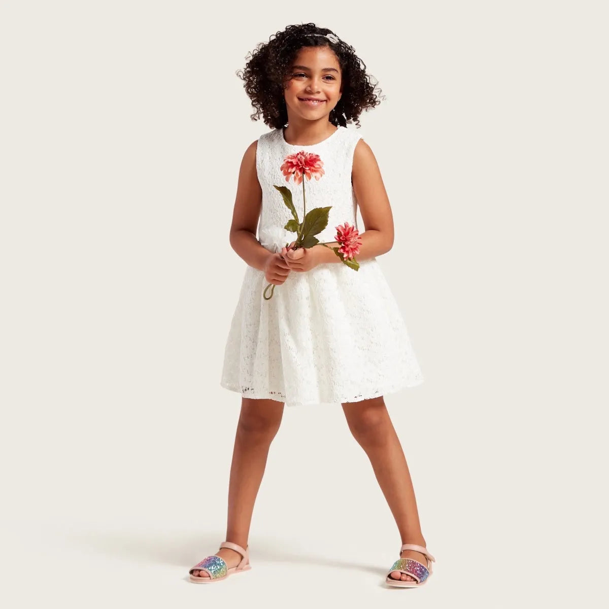White sleeveless baby dress with pink rose print and flared skirt