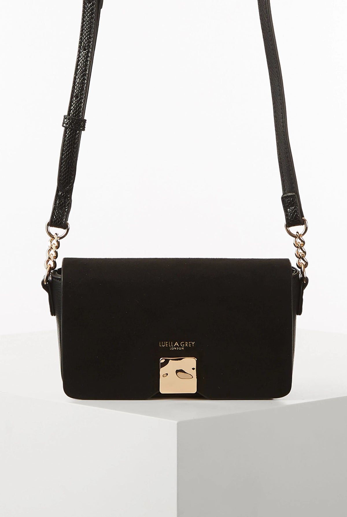 Black flap shoulder bag with gold-tone clasp and adjustable braided strap
