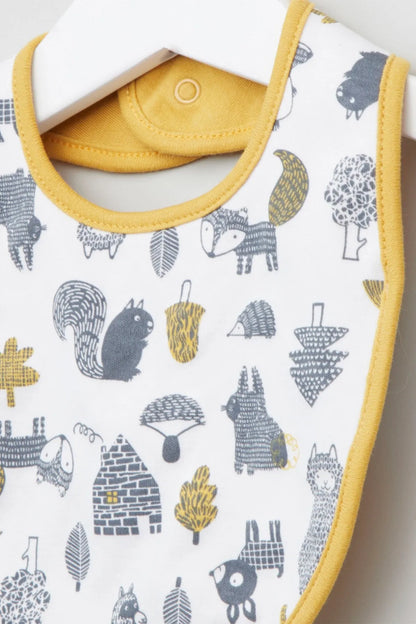 Baby bib close-up with animal icons on white, yellow edging and snap