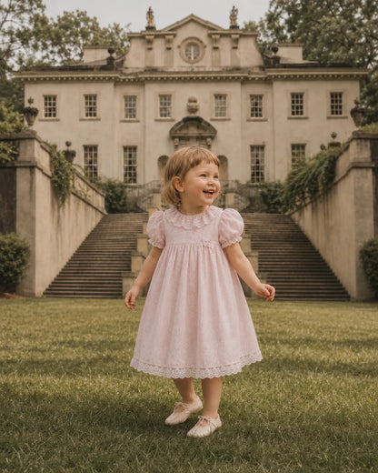 Light pink toddler dress with lace collar, puff sleeves, and full twirly skirt