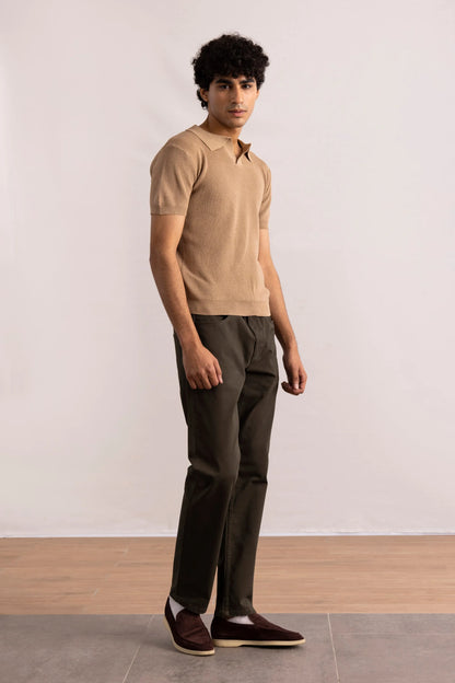 Brown knit polo shirt worn with dark trousers and low-profile sneakers