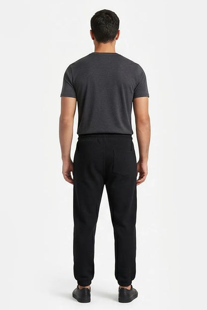 Black jogger pants with elastic waistband and ankle cuffs, back view