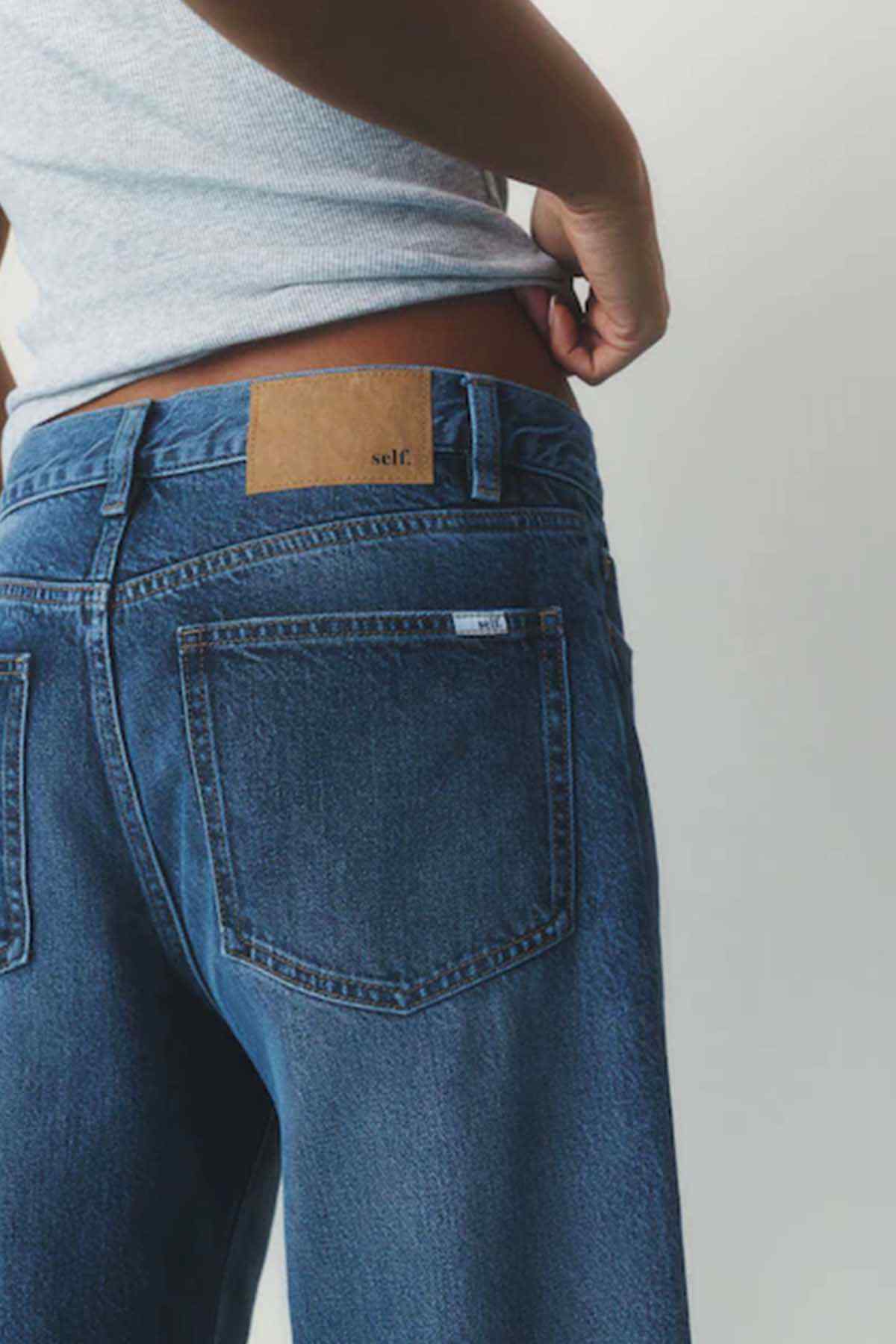 Women's dark blue denim jeans waist label and back yoke with stitched pockets
