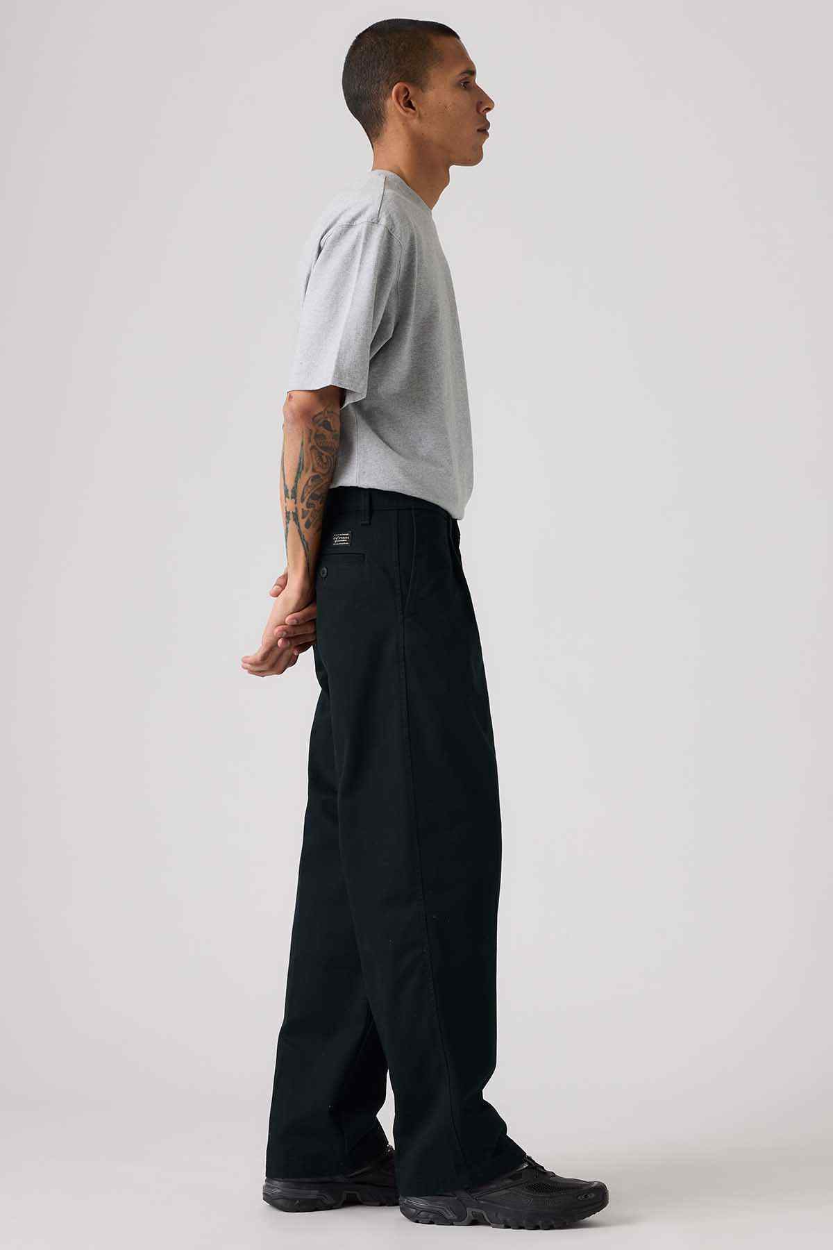 Levi's black wide-leg pants with gray crew-neck T-shirt, side view