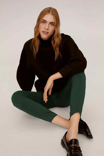 Mango black hoodie and green slim pants, front view, hands on hips