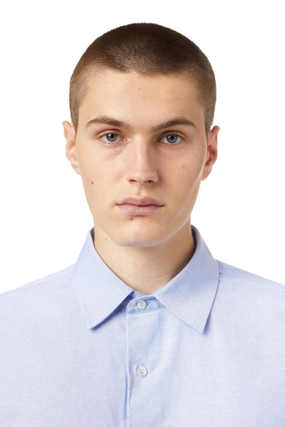 Men's light blue dress shirt close-up, buttoned collar and logo patch