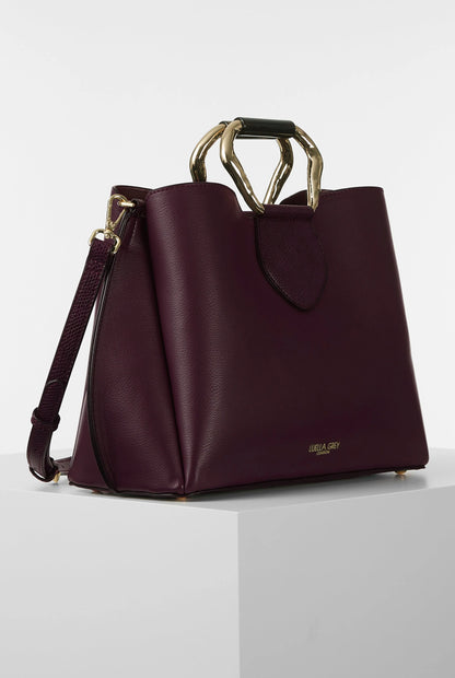 Dark purple structured handbag with top handle ring and detachable shoulder strap