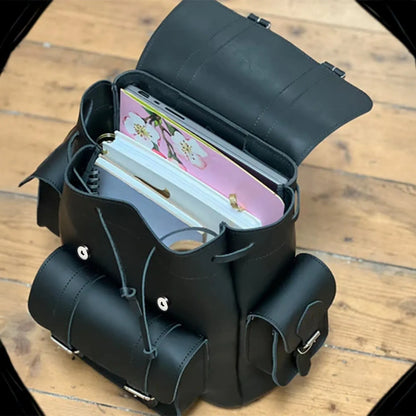 Open black backpack showing interior pouch with small elastic strap and zipper