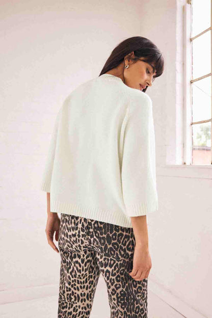 Ecru knit sweater back view with ribbed hem and cuffs