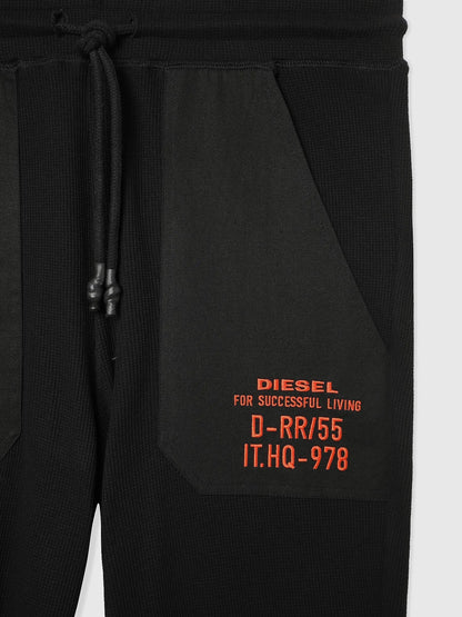 Black jogger pants close-up: side graphic text label near pocket