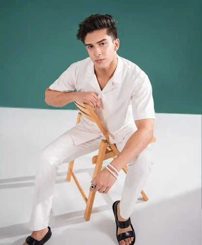 Off-white fitted short-sleeve shirt with V-neck, full-length matching pants with creases