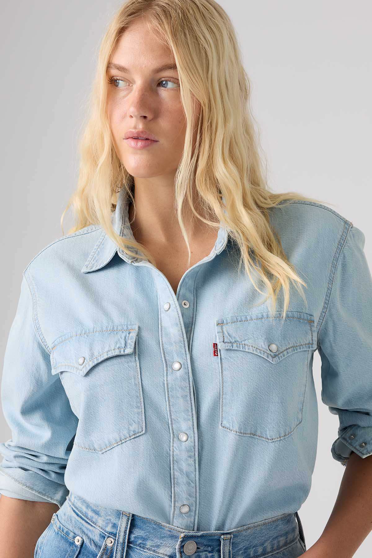 Light blue denim button-up shirt with snap-flap chest pockets, long sleeves