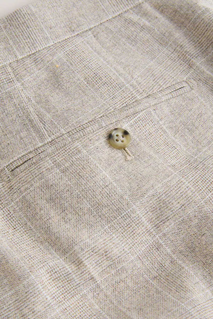 Light beige trouser cuff with small round button and stitched placket