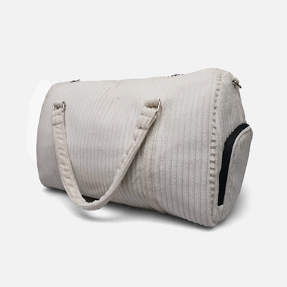 Cream ribbed duffel bag with shoulder strap, side zipper, and contrast black trim
