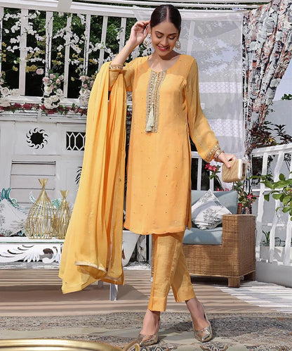 Yellow embroidered tunic with lace trim, matching pants, and sheer dupatta