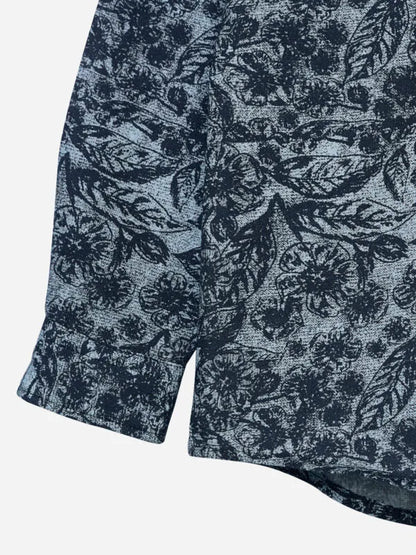 Cotton shirt hem close-up with dark leaf print on a grey base