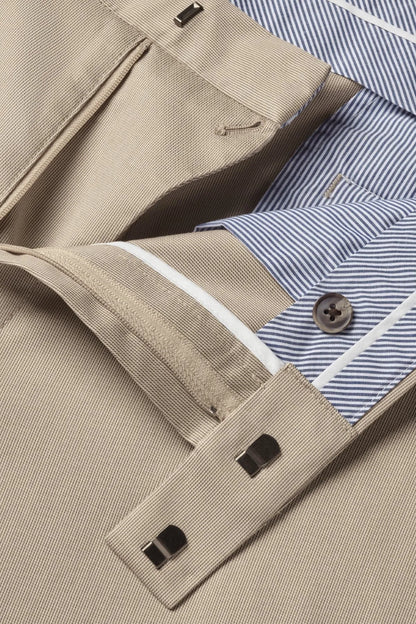 Men's neutral trousers detail view, belt loops and buttoned front pocket