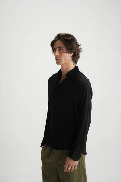 Black button-up shirt on model, three-quarter side view with collar and sleeves.