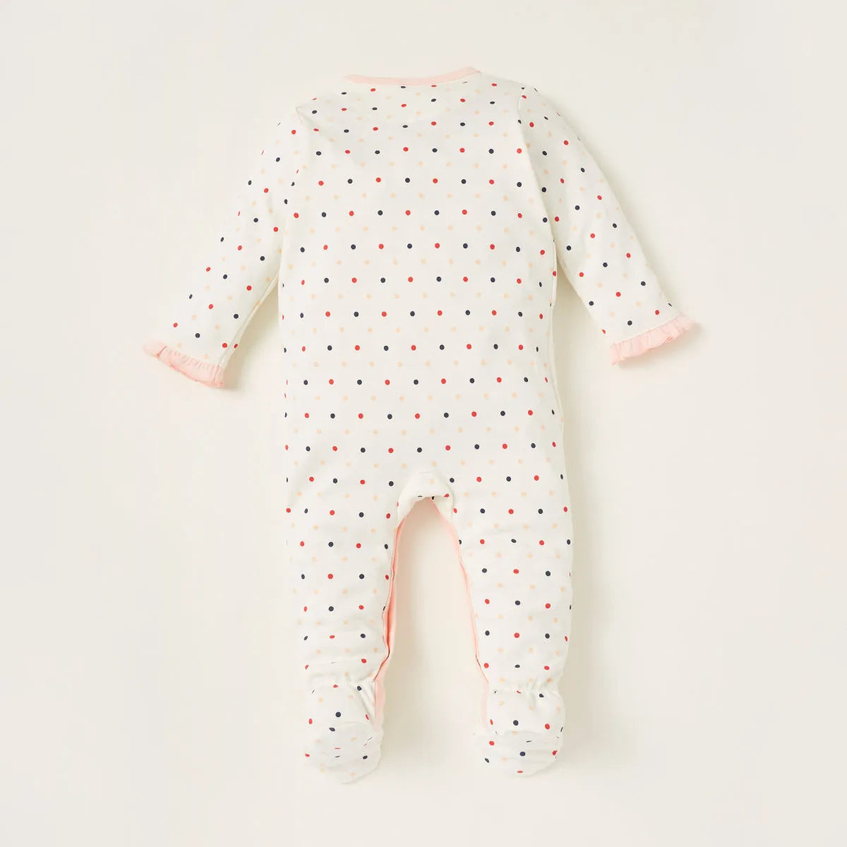 White baby footless romper with multicolor dots and pink-trim back opening