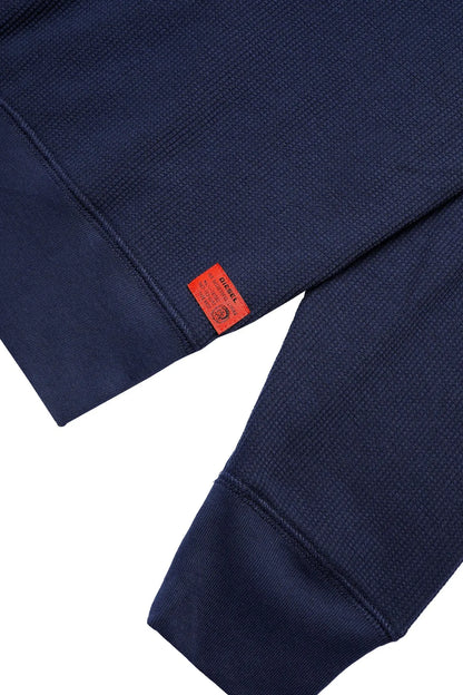 Dark blue Diesel sweatshirt sleeve detail with orange size tag and stitched cuff