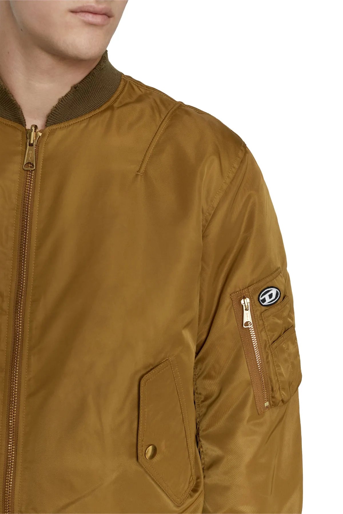 Tan bomber jacket sleeve detail with zip pocket and snap flap