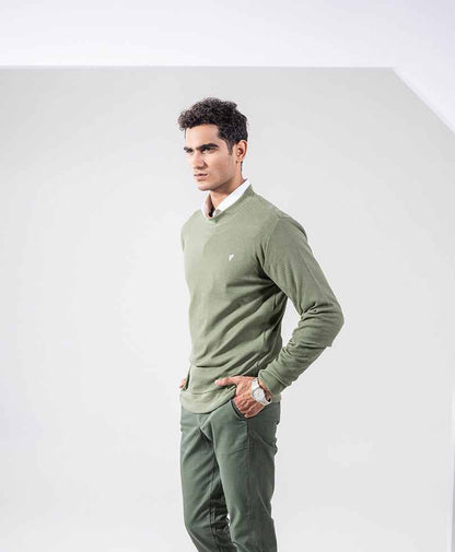 Men's fitted olive-green knit sweater with crew neck and small chest logo, side view